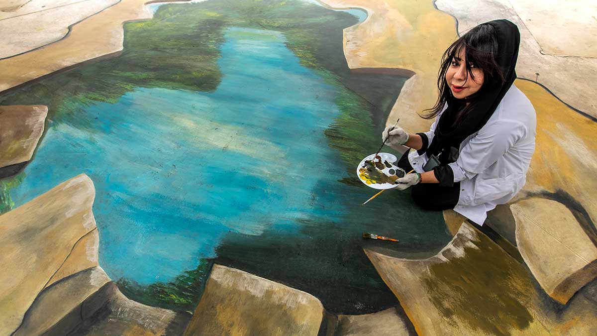 Afaf Salman working on her mangrove art outside of the Dhahran al-Mujamma'