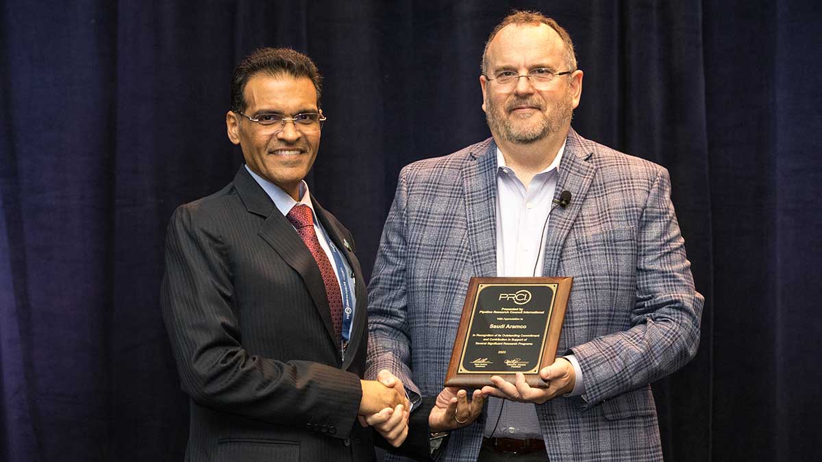 Southern Area Pipelines director Abdullah M. Al-Ajmi shakes hands with PRCI president Cliff Johnson. Al-Ajmi accepted a plaque on behalf of Aramco